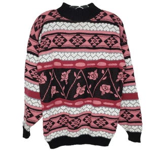 May include: A vintage sweater with a high neck and long sleeves. The sweater features a pattern of pink, black, white, and gray geometric shapes and floral designs. The cuffs and neckline are black.