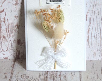 Wedding congratulations card with dried flowers and wishes of happiness.