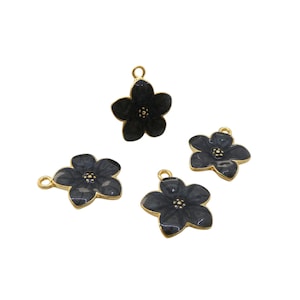 Może przedstawiać: Cztery ciemnoszare zawieszki w kształcie kwiatów ze złotymi obwódkami i pętelkami do tworzenia biżuterii. Płatki kwiatów mają subtelny efekt marmurkowy. Zawieszki są na białym tle.