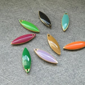 Peut inclure: Collection de breloques ovales en émail de différentes couleurs, dont vert, noir, turquoise, marron, orange, violet et bordeaux. Chaque breloque a un bord doré et un petit trou pour l'enfilage. Idéal pour la création de bijoux.