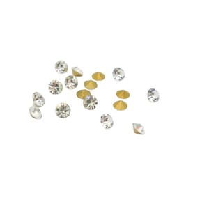 Peut inclure: Une dispersion de strass clairs et irisés avec des montures dorées. Les strass sont de différentes tailles et formes.
