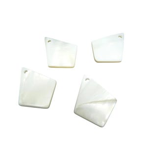 Peut inclure: Quatre pendentifs en coquillage blanc irisé de forme géométrique. Chaque pendentif comporte un petit trou en haut pour l'enfilage. Les pendentifs sont disposés sur un fond blanc.