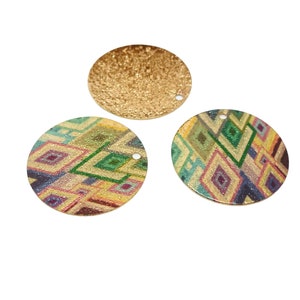 Peut inclure: Trois ornements ronds en métal de couleur dorée. Un ornement est en or massif, tandis que les deux autres présentent un motif géométrique dans des tons de vert, jaune, bleu et violet.