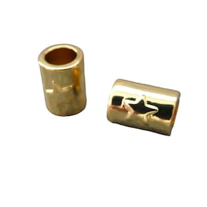 May include: Two gold-colored metal bead spacers with a star design. The spacers are cylindrical in shape and have a smooth, shiny finish.