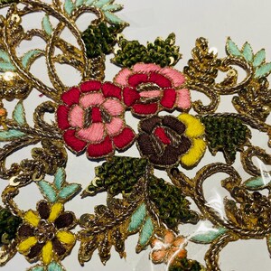 May include: A floral embroidery applique with gold thread, sequins, and colorful flowers in shades of pink, red, green, yellow, and orange.