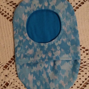 Puede incluir: Una bolsa de tela azul y blanca con un patrón y una abertura redonda. La bolsa está forrada con una tela azul sólida.