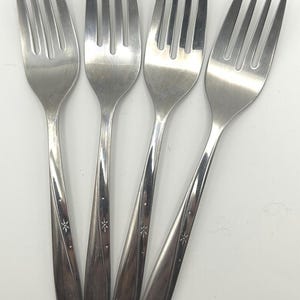 Puede incluir: Una taza de cerámica blanca con un asa negra y el texto "But First, Coffee" en negro, con una fuente de estilo manuscrito. La taza está sobre una superficie blanca.