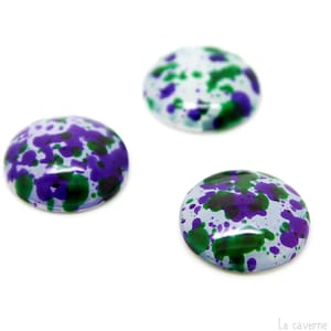 Peut inclure: Trois cabochons ronds blancs avec un motif de peinture verte et violette en éclaboussures.