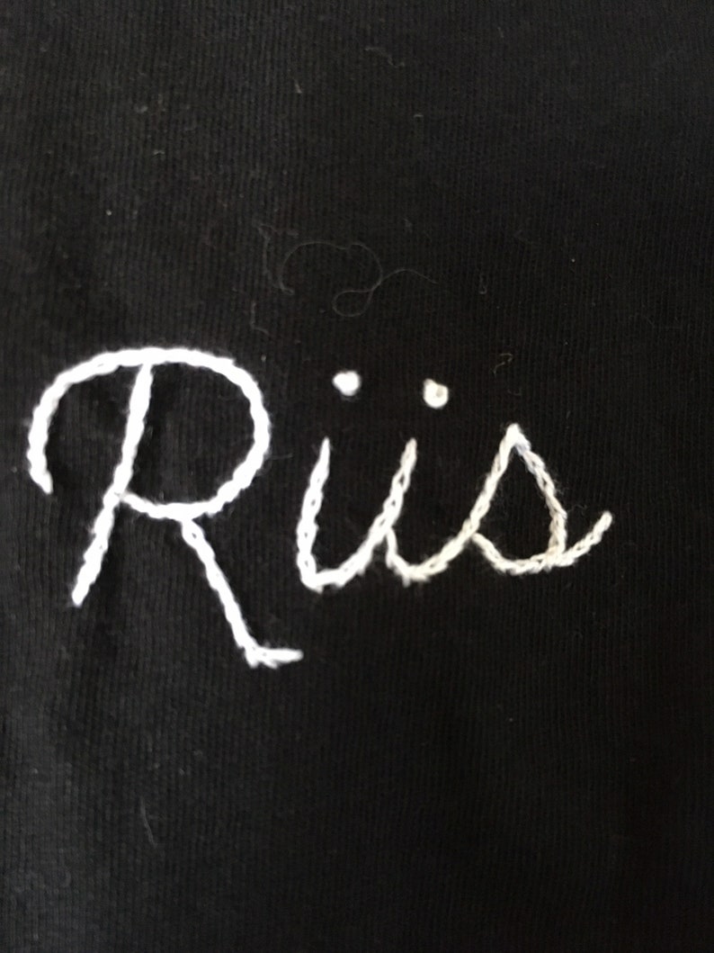 Riis hand embroidered in bright white on an unworn black tank by me Tank is originally from Top Man and is a men\u2019s size small but I\u2019d go b