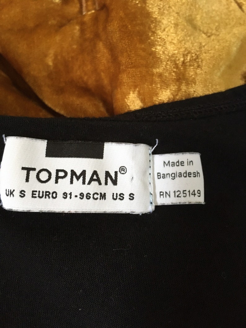 Riis hand embroidered in bright white on an unworn black tank by me Tank is originally from Top Man and is a men\u2019s size small but I\u2019d go b