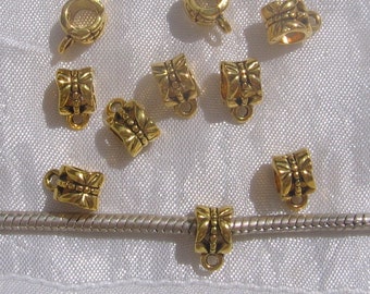 May include: Ten gold-toned metal bead caps with a decorative butterfly design. The caps have a small loop at the top for attaching to jewellery.