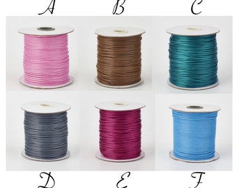 May include: Six spools of cord in different colors: pink, brown, teal, gray, burgundy, and light blue. Each spool is wound with cord and has a white label.