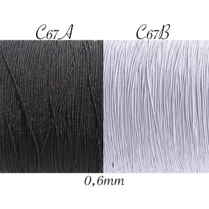 Puede incluir: Dos carretes de hilo, uno negro y otro morado claro, etiquetados como C67A y C67B. El hilo tiene un grosor de 0,6 mm.
