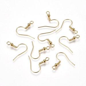 May include: A close-up of eight gold-toned earring hooks with spring-loaded clasps. The hooks are scattered on a white surface.
