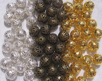 Puede incluir: Una colección de cuentas de metal decorativas en colores plateado, dorado y bronce. Las cuentas tienen un diseño texturizado y calado y son perfectas para la elaboración de joyas o proyectos de artesanía.