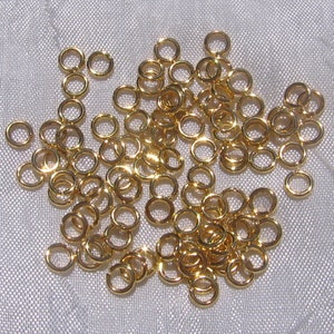 Könnte beinhalten: Ein großer Haufen goldener Sprungringe. Die Ringe sind klein und rund und perfekt zum Schmuckmachen.