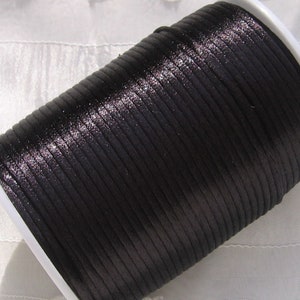 Puede incluir: Una bobina de cord&oacute;n de sat&eacute;n negro, un tipo de cord&oacute;n delgado, plano y liso que se utiliza a menudo para la elaboraci&oacute;n de joyas y manualidades.