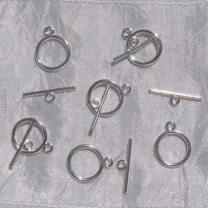 May include: Silver toggle clasps with a round ring and a bar. The clasps are designed for jewelry making and crafting.