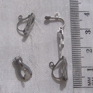 May include: Four silver-toned clip-on earring backs. The backs are designed to be used with earrings that have a post.