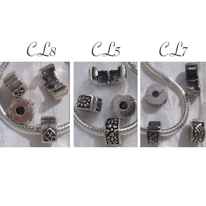 Pode incluir: Três espaçadores de pulseira de berloques de prata com intrincados desenhos florais. Os espaçadores são etiquetados como "CL8", "CL5" e "CL7".