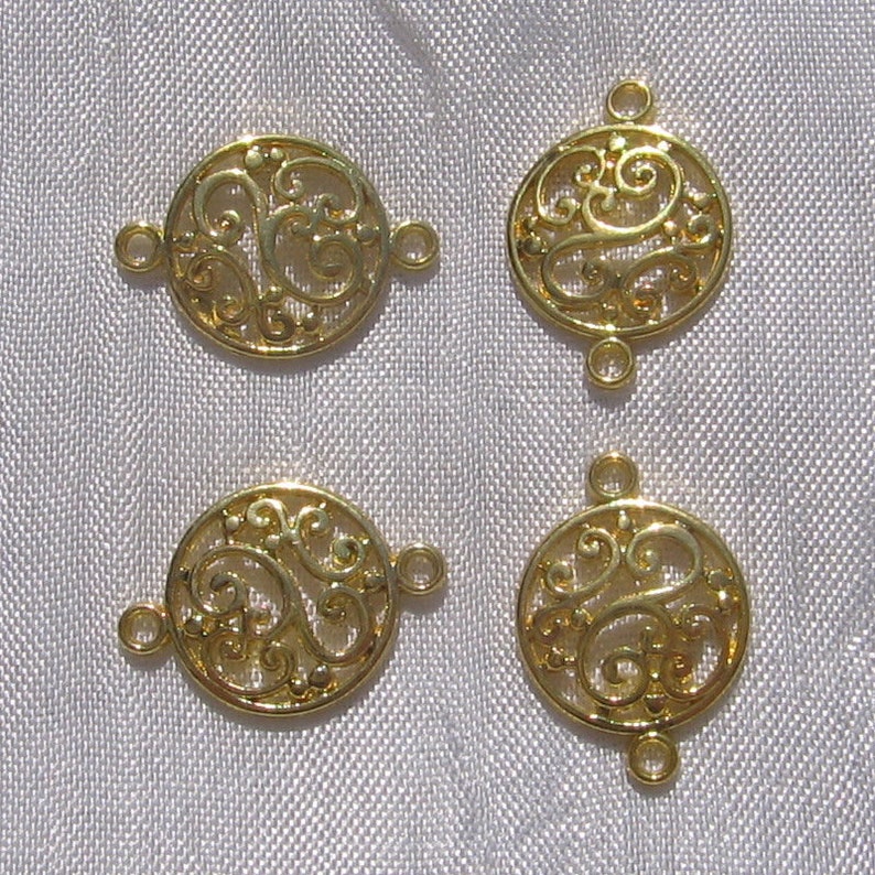 Pu&ograve; includere: Quattro ciondoli connettore in metallo dorato con un design a filigrana decorativo. Ogni ciondolo ha due anelli a salto per il fissaggio ai gioielli.