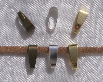 May include: Assortment of six metal pendant clasps in silver, gold, and bronze. The clasps are in various shapes and sizes.