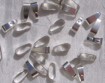 May include: A group of silver-toned metal pendant bails, used for attaching pendants to necklaces or chains. The bails are oval-shaped with a small loop at the top.