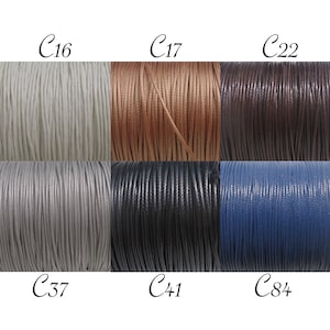 Pode incluir: Seis rolos de cordão em diferentes cores: branco, castanho, castanho escuro, cinzento, preto e azul. Os rolos são etiquetados com os códigos C16, C17, C22, C37, C41 e C84.
