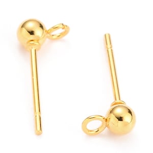 Könnte beinhalten: Ein Paar goldfarbene Ohrstecker mit einer kleinen Kugel am Ende jedes Stiftes. Jeder Stift hat eine kleine Schlaufe oben.