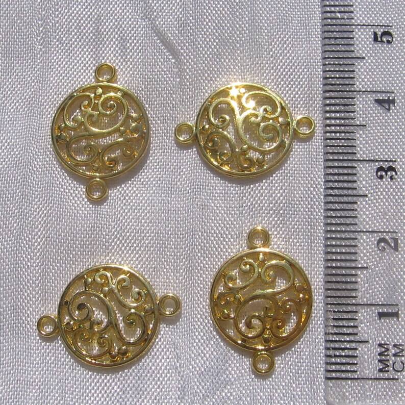 Pu&ograve; includere: Quattro connettori circolari in filigrana di metallo color oro con due anelli a salto su ciascuno. I connettori misurano circa 3,8 cm di diametro.