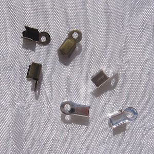 Pode incluir: Conjunto de fechos metálicos para a fabricação de joias. Os fechos são em tons prata e bronze. Alguns fechos têm um laço em uma extremidade e um gancho na outra.