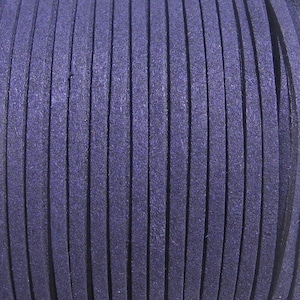 Può includere: Primo piano di una bobina di cordoncino in pelle scamosciata blu scuro. Il cordoncino è avvolto strettamente, con strisce verticali di pelle scamosciata visibili. La trama appare morbida e leggermente sfocata, ideale per l'artigianato e la gioielleria.