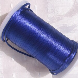 Puede incluir: Un carrete de cord&oacute;n de sat&eacute;n azul real, enrollado apretado y listo para proyectos de manualidades.