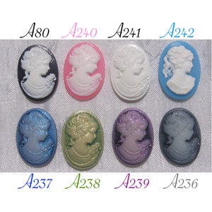 Può includere: Assortimento di dieci bottoni a cammeo ovali con un'immagine a cammeo bianca di un profilo femminile. I bottoni sono di vari colori, tra cui nero, rosa, blu, verde, viola e grigio.