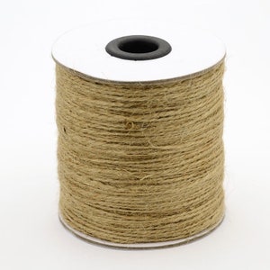 May include: A roll of natural brown twine wrapped around a white cardboard spool. The twine is made of natural fibers and is perfect for crafting, wrapping, and decorating.