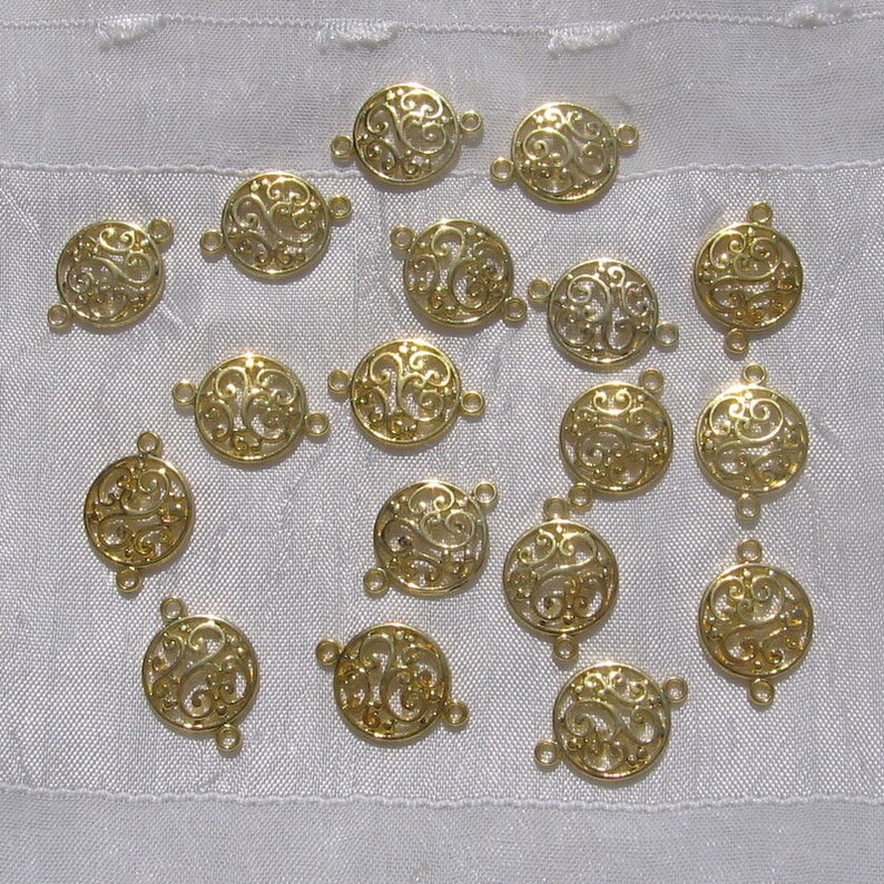 Pu&ograve; includere: Una collezione di 18 ciondoli connettore in metallo dorato con un design a filigrana decorativo. Ogni ciondolo ha due anelli a salto per il fissaggio a gioielli o altri oggetti artigianali.