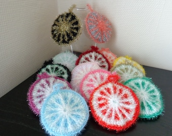 Peut inclure: Une collection de torchons à vaisselle en crochet de différentes couleurs avec un motif de flocon de neige. Les torchons sont faits de fil scintillant et sont disposés en forme de pyramide.
