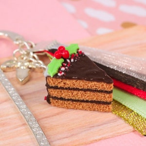 Realistic chocolate Christmas cake bookmarks in polymer clay mounted on a classic silver ring with matching ribbons and holly charm