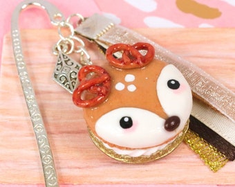 Bookmarks Reindeer macaron with a golden shell and white whipped cream for Christmas mounted on a silver stand with matching ribbons