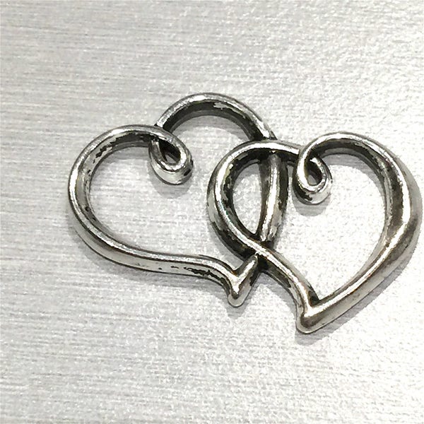 Coeur. Deux cœurs entrelacés  : UN pendentif en métal argenté  (sans plomb) de style tibétain, 24 x 31 mm