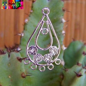 Può includere: Componente per orecchino in metallo argentato a forma di lacrima con intricati disegni circolari. L'orecchino ha più anelli per attaccare perline o altri elementi di gioielleria.