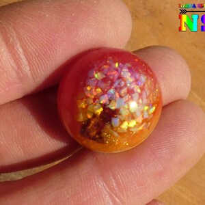 Ronde lichtgevende cabochon van 2 cm, unieke ambachtelijke creatie in epoxyhars, hout en witte opalen, oranjegele zon gloeit in het donker