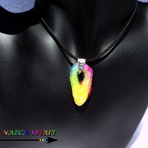 Op de afbeelding: Een kleurrijke hangerketting met een regenboogkleurige steen. De steen is een mix van geel, groen, roze en paars en hangt aan een zwart koord. De hanger is bevestigd aan een zilverkleurige metalen sluiting.