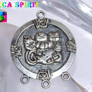 Può includere: Ciondolo in argento con un designo dettagliato di una figura di spirito Nazca. Il ciondolo ha tre anelli per attaccarlo a una catena o un cordino.