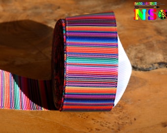 Op de afbeelding: Een rol kleurrijk gestreept lint met rode, oranje, gele, groene, blauwe, paarse en roze strepen. Het lint is om een witte spoel gewikkeld.