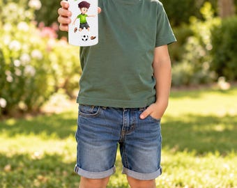 May include: A white metal water bottle featuring a graphic of a cartoon soccer player and the name Tom in green text. The bottle has a black screw-top lid with a silver metal carabiner clip attached for easy carrying and attachment.
