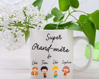 May include: White ceramic mug with black text that reads "Super Grand-mère de L'éa Tim Léo Sophie". The mug has a cartoon illustration of four children with backpacks.