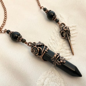 Divination pendulum with an onyx tip and obsidian beads, copper-colored metal crow skull for dowsing divination