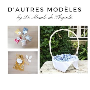 May include: A white wicker basket filled with blue and white fabric favor bags. The basket is sitting on a wooden table with green foliage in the background. The text "D'AUTRES MOD&Egrave;LES by Le Monde de Physalis" is at the top of the image.