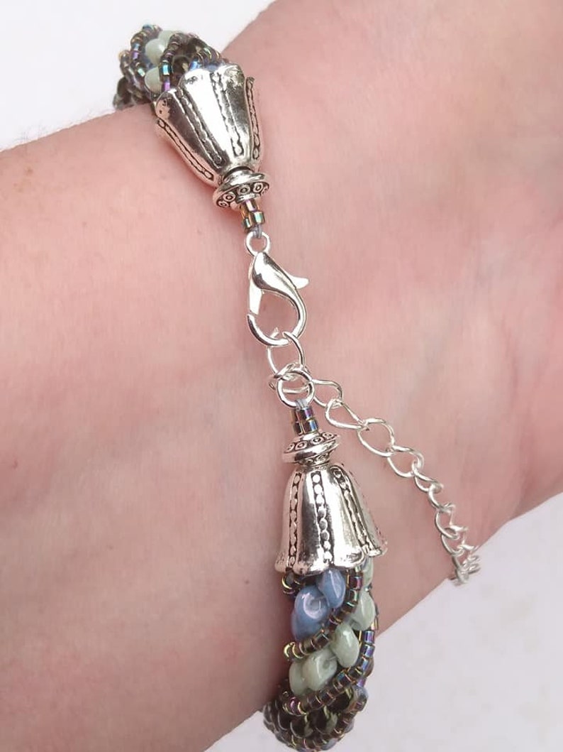 Needle-woven Flavie bracelet spiraled with Matubo superduo beads and Miyuki D\u00e9licas greenbluebronze primers without nickel